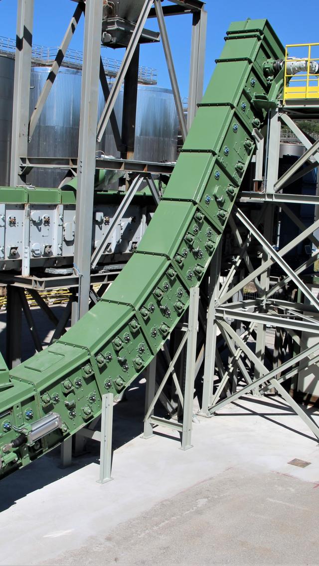 Bucket conveyor for hot clinker transport at steep inclines